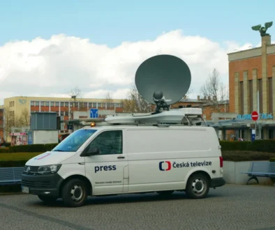 Před budovou parkuje auto ČT1.