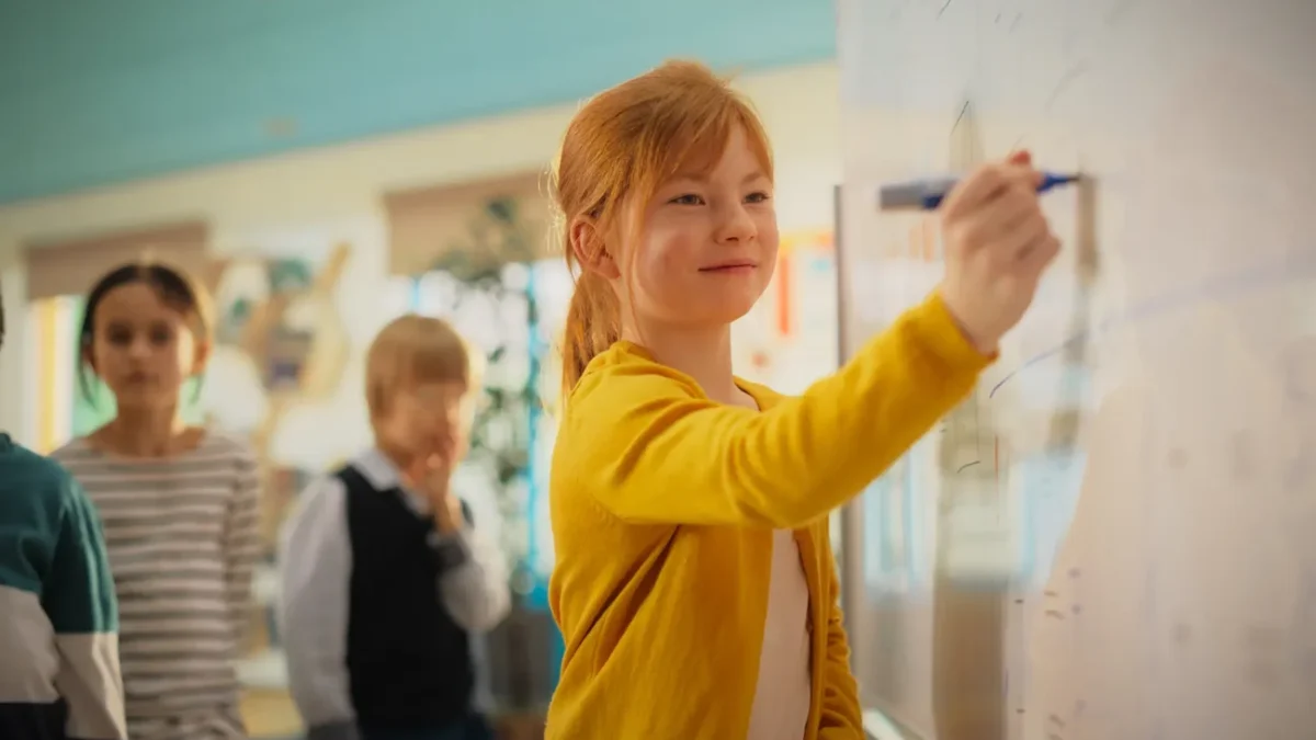 dítě počítá příklad na tabuli