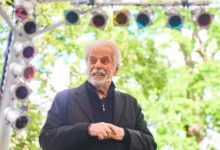 Starší muž se dívá před sebe.