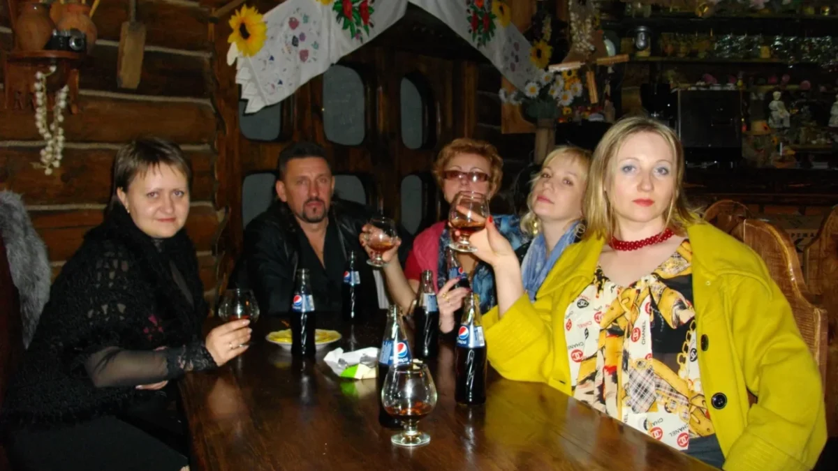 Retro oblečení lidé sedí kolem stolu.