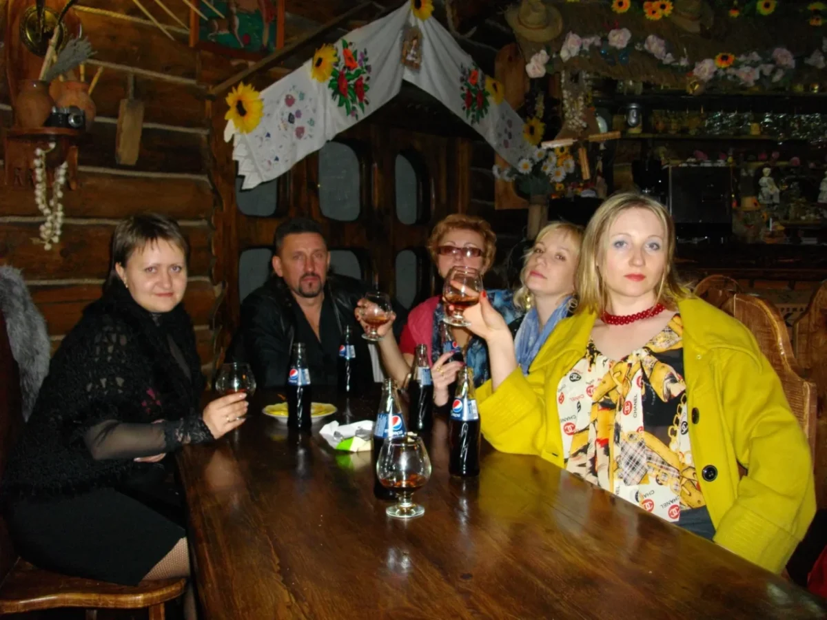 Retro oblečení lidé sedí kolem stolu.