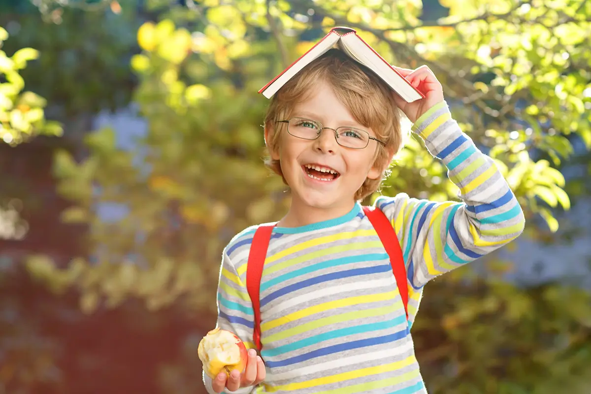 Rébusy představují pro děti zábavnou výzvu. | TVGURU.cz kluk s učebnicí na hlavě