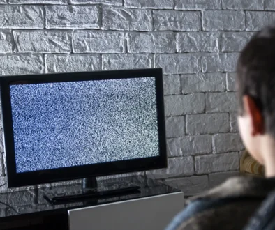 Muž se dívá na televizi, která nic nevysílá.