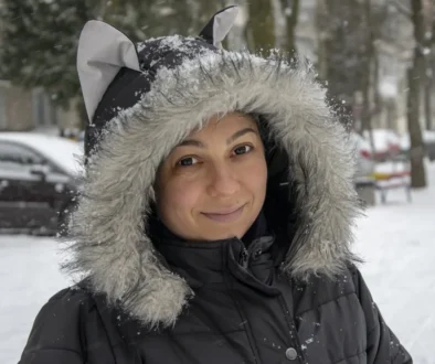 Žena s kapucí na hlavě stojí venku.