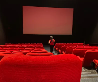 Žena se prochází uličkou v kině.