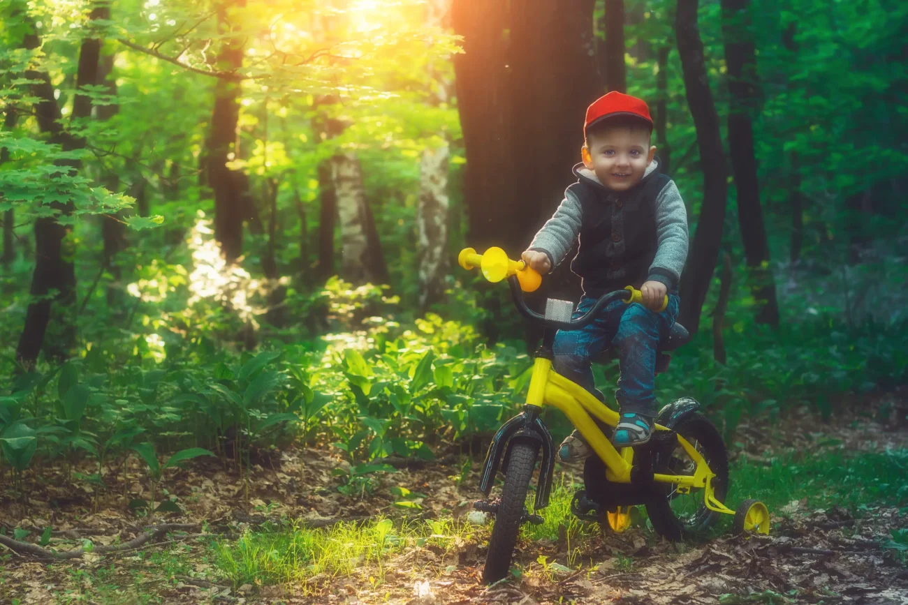 shutterstock_1103706638 | TVGURU.cz Chlapeček jede na kole lesem.