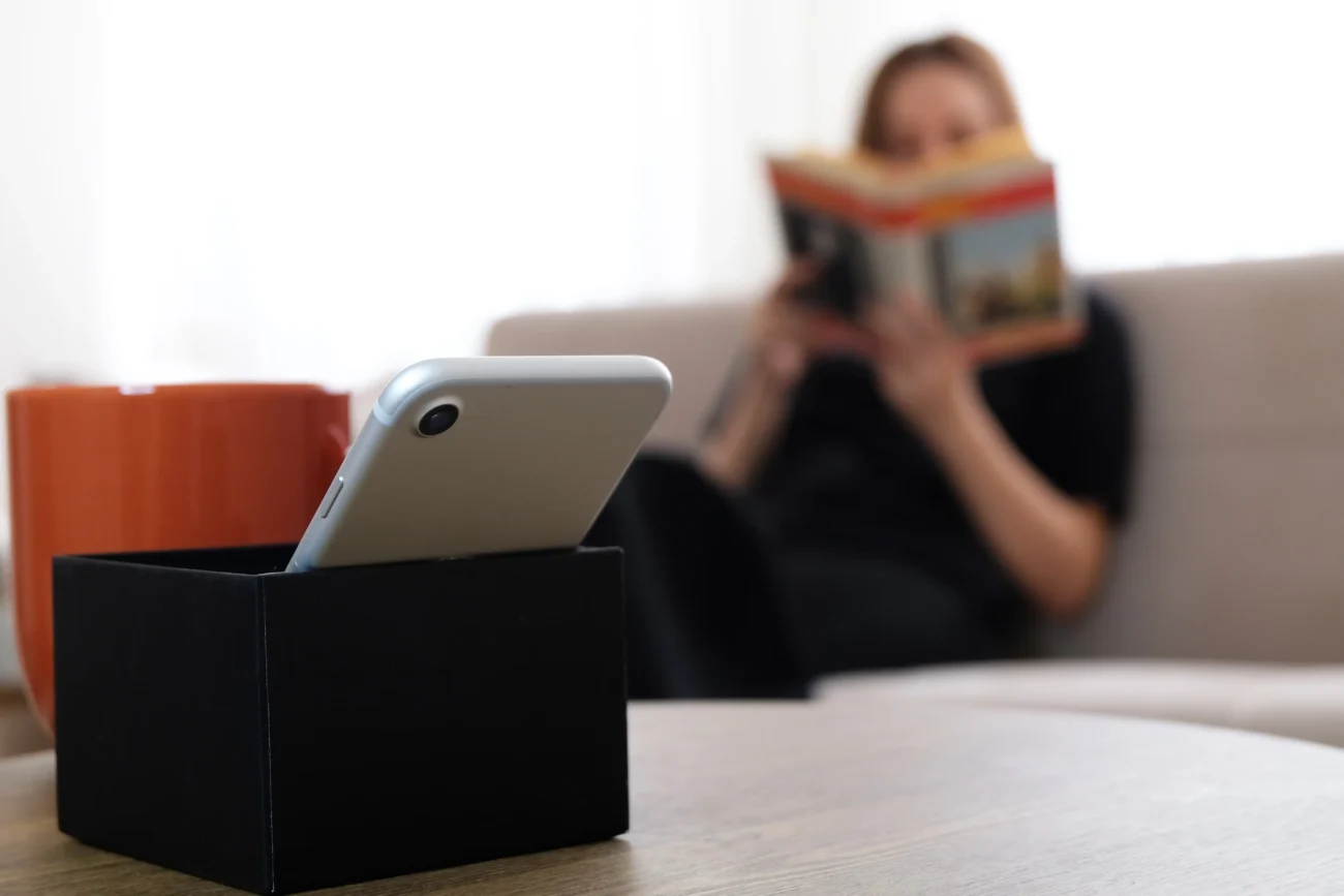 Žena sedí na gauči a čte si. 