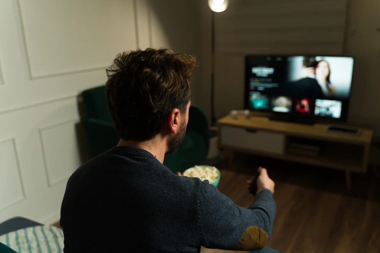muž sleduje TV