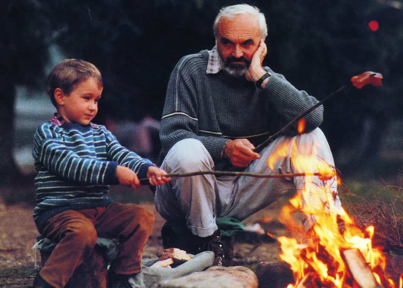 Zdeněk Svěrák a Kolja sedí u ohně.