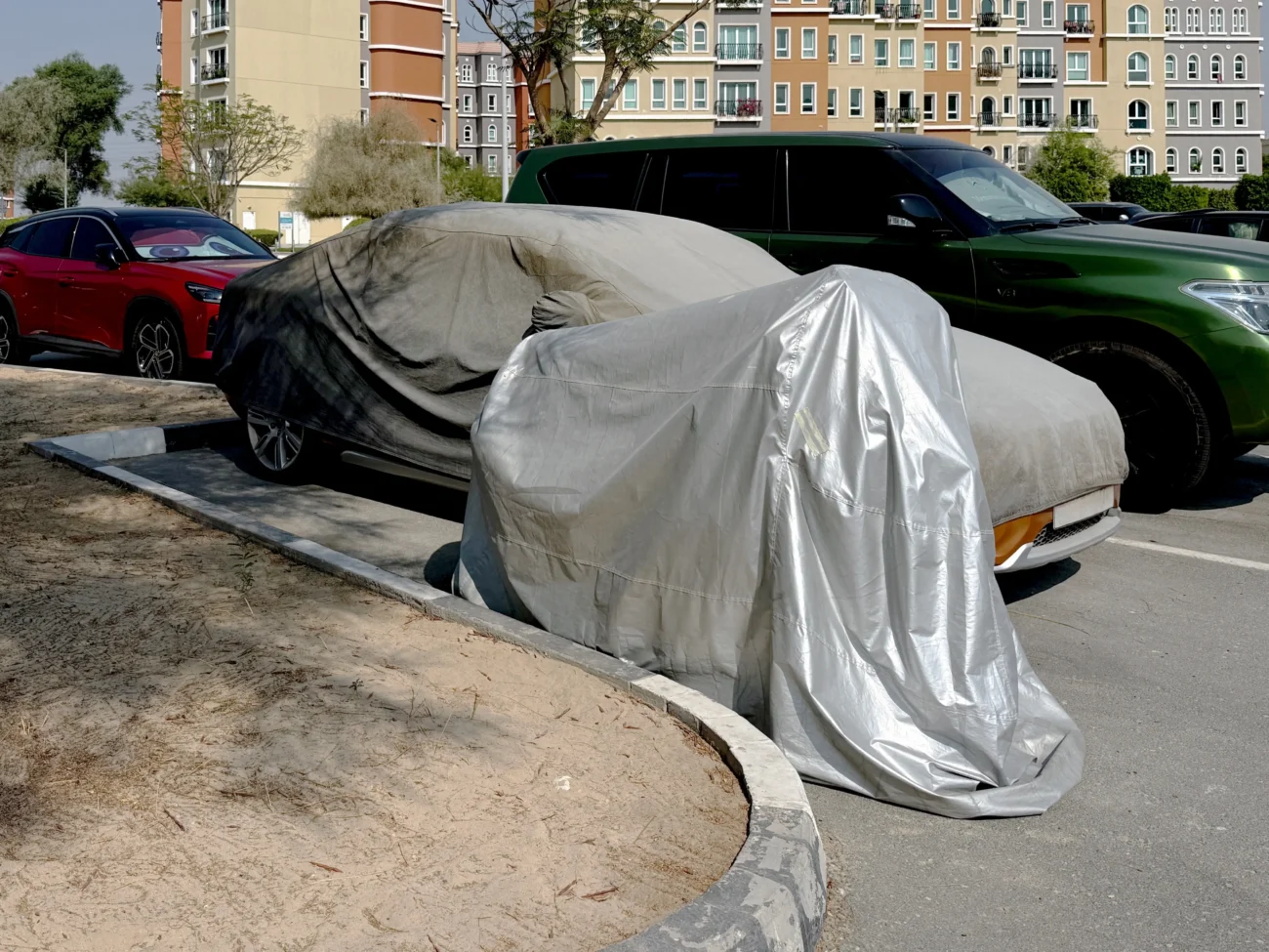 Na parkovišti stojí zakrytá auta.