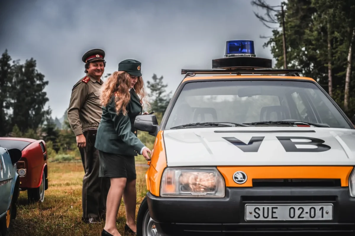 Lidé stojí u auta VB.