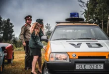 Lidé stojí u auta VB.