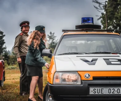 Lidé stojí u auta VB.