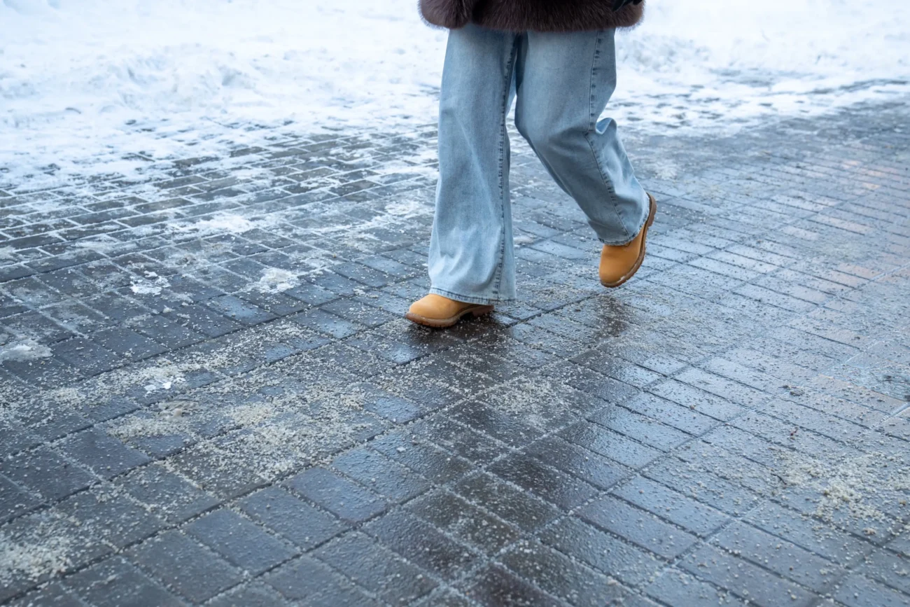 Žena jde po zledovatělé cestě.