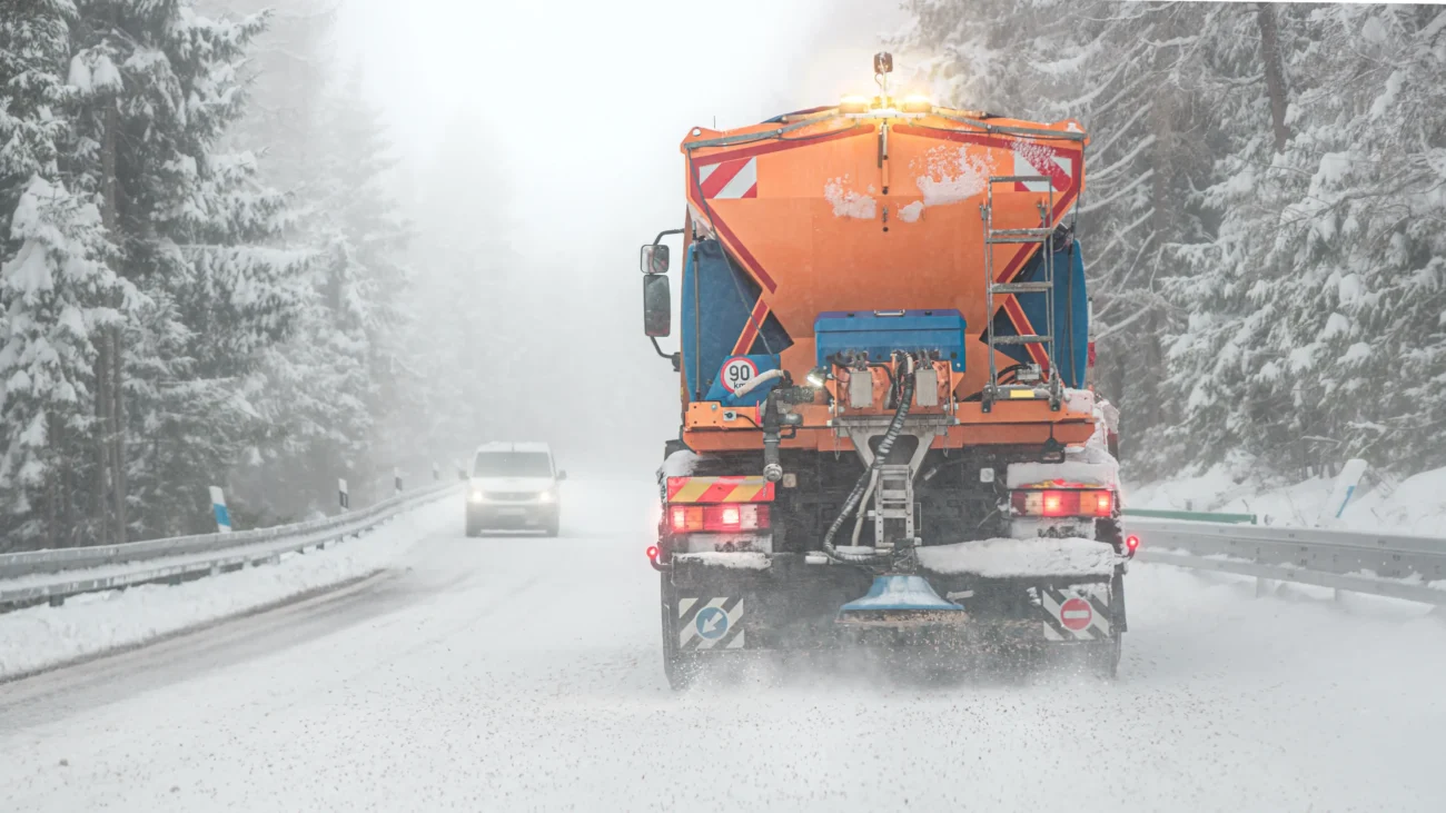 Auta jedou po zasněžené silnici. 