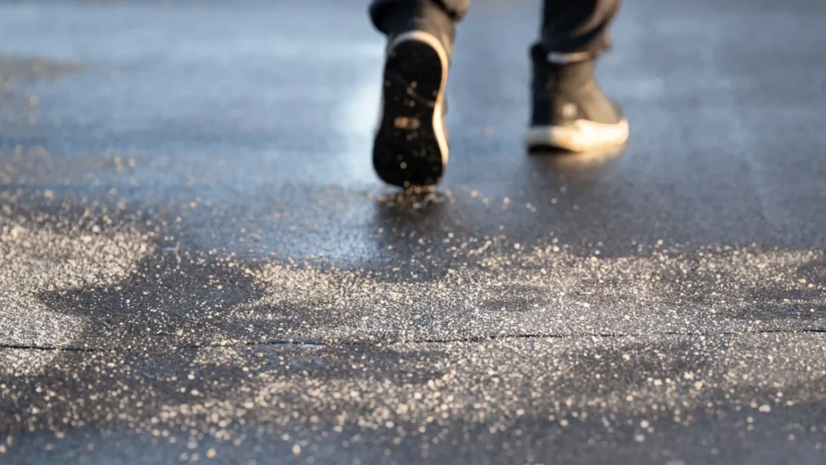 Muž jde po zmrzlé silnici.