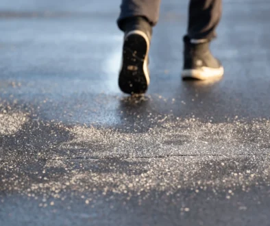 Muž jde po zmrzlé silnici.