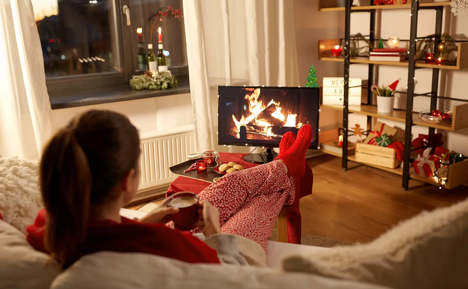 žena sleduje hořící krb v televizi