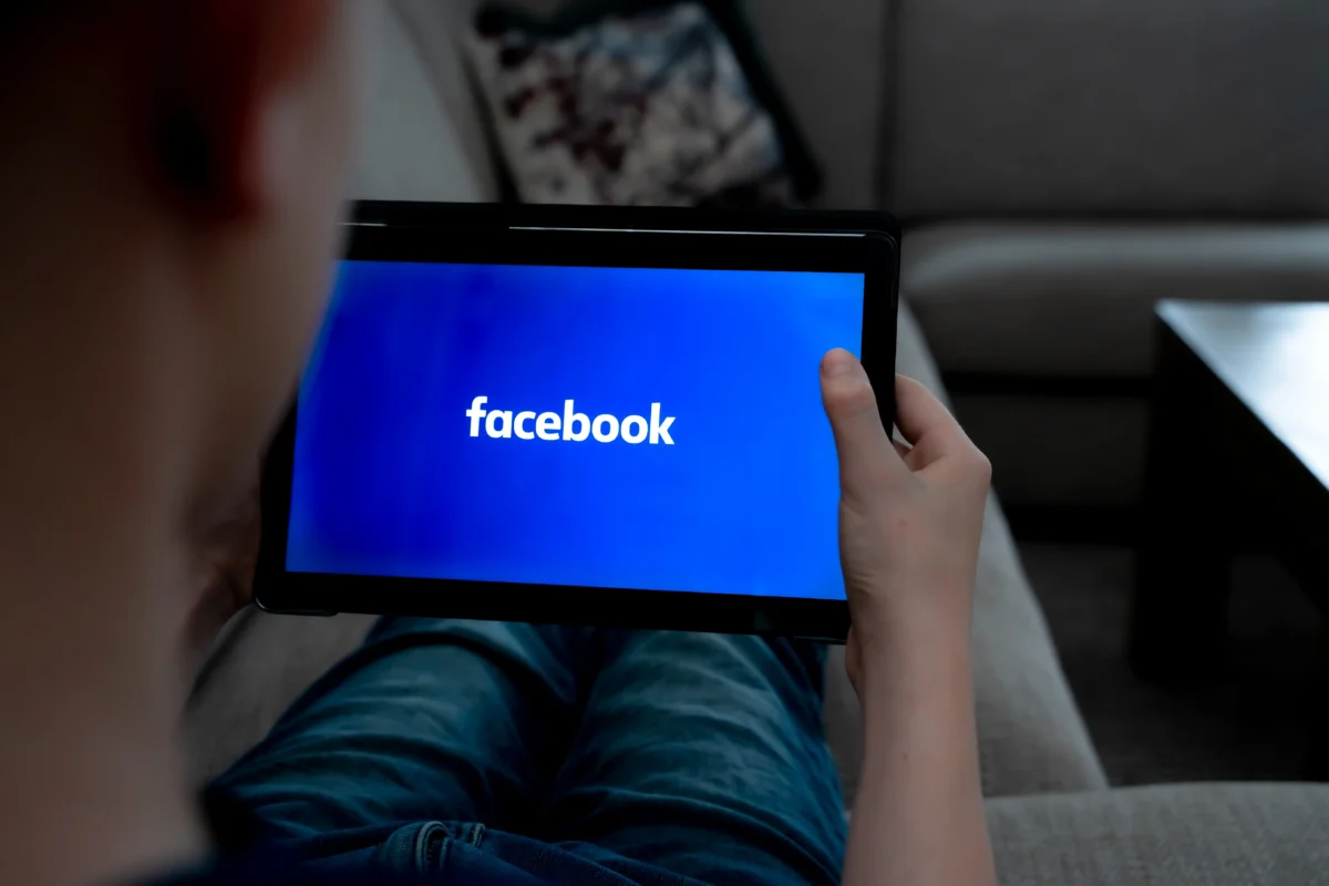 Člověku se na tabletu zapíná Facebook.