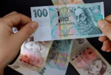 žena drží v ruce peníze