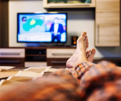 muž se dívá z postele na televizi