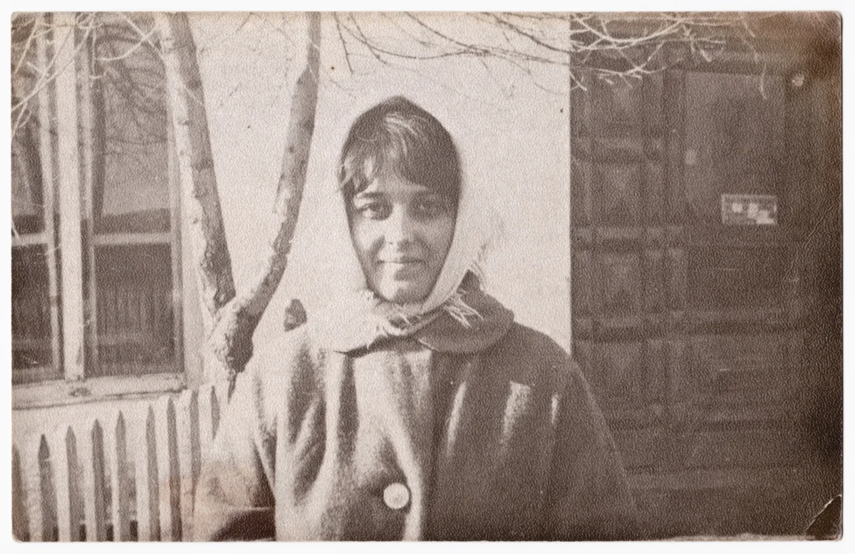 Na staré fotce se usmívá paní. 