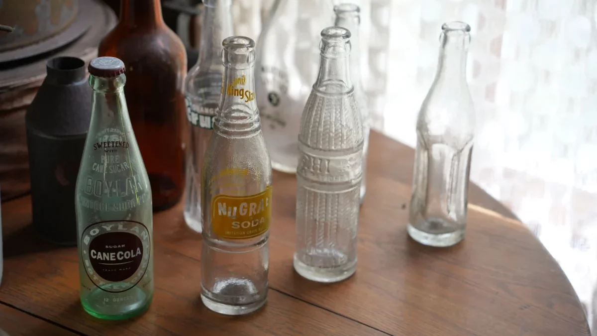 Na stole stojí staré skleněné láhve.