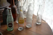 Na stole stojí staré skleněné láhve.