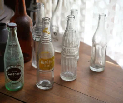 Na stole stojí staré skleněné láhve.