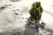 LEGO postavička leží na pláži.