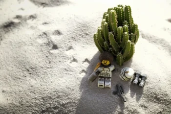 LEGO postavička leží na pláži.