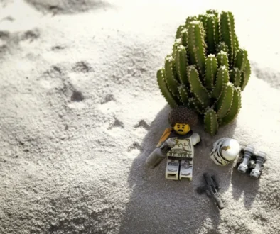 LEGO postavička leží na pláži.