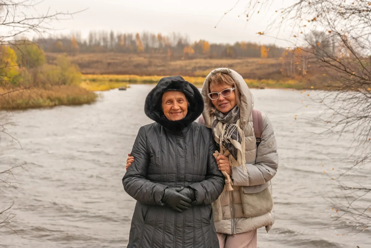 Ženy se objímají a stojí u vody.