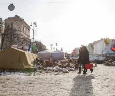 Lidé se prochází po zdevastovaném městě.