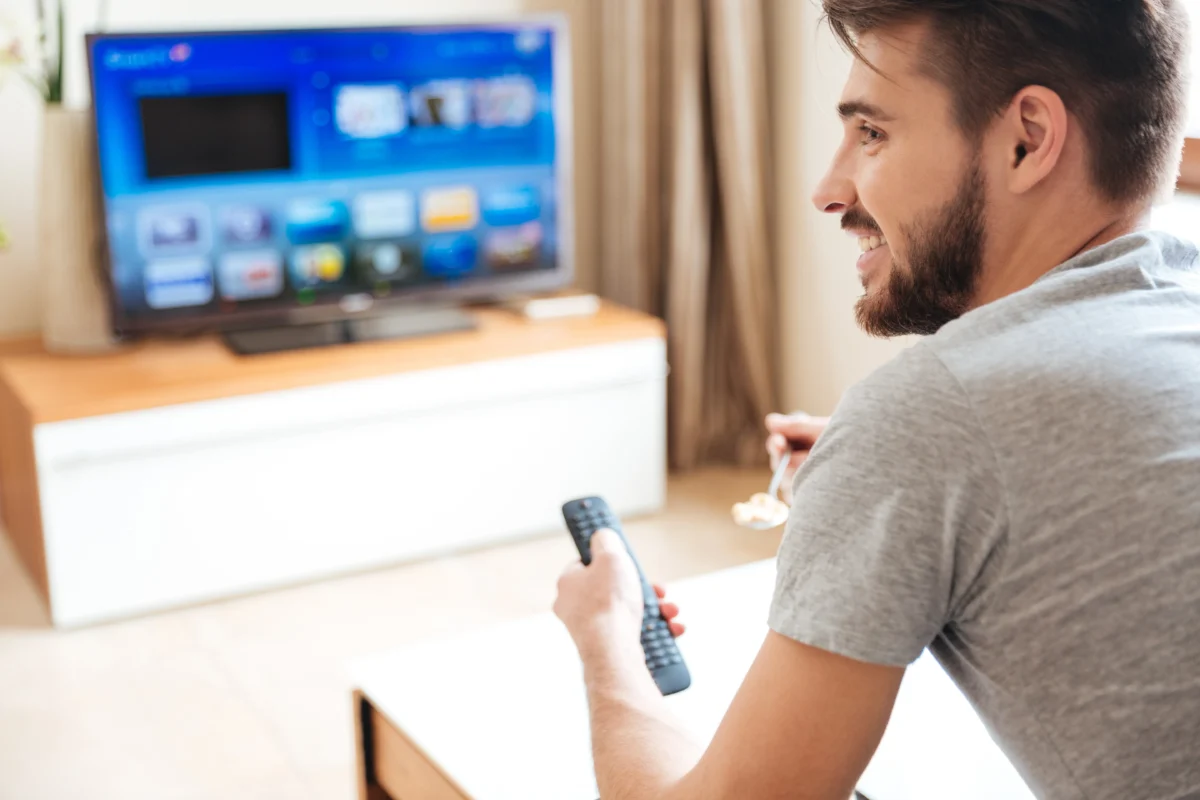 muž sleduje TV