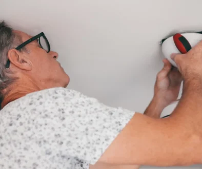 Muž něco šteluje u stropu.