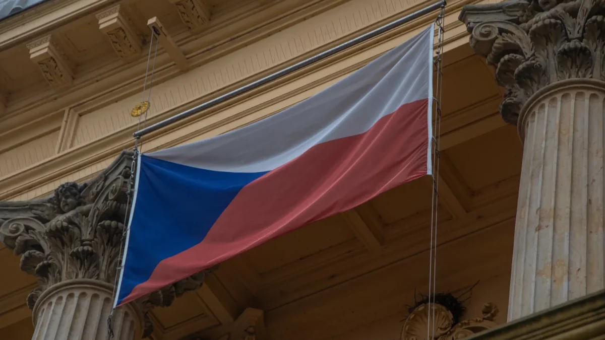 Na budově visí česká vlajka.