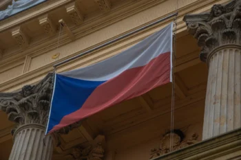 Na budově visí česká vlajka.