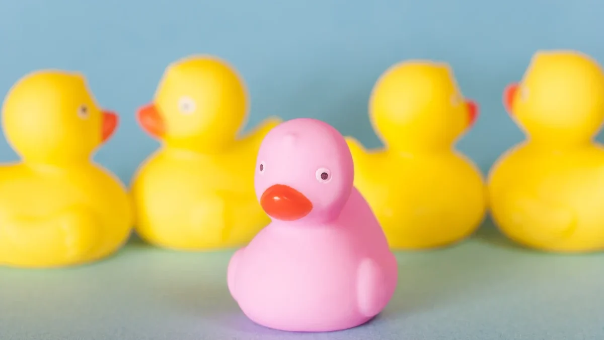 Růžová kačenka vyčnívá mezi žlutými.