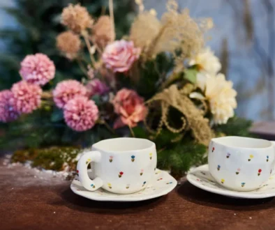 Před květinou stojí dva hrnky.