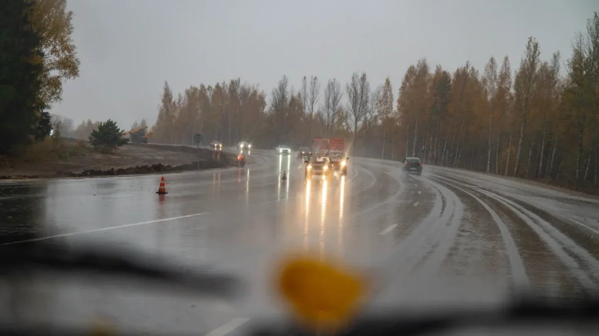 Auto jede po silnici, když mrholí.