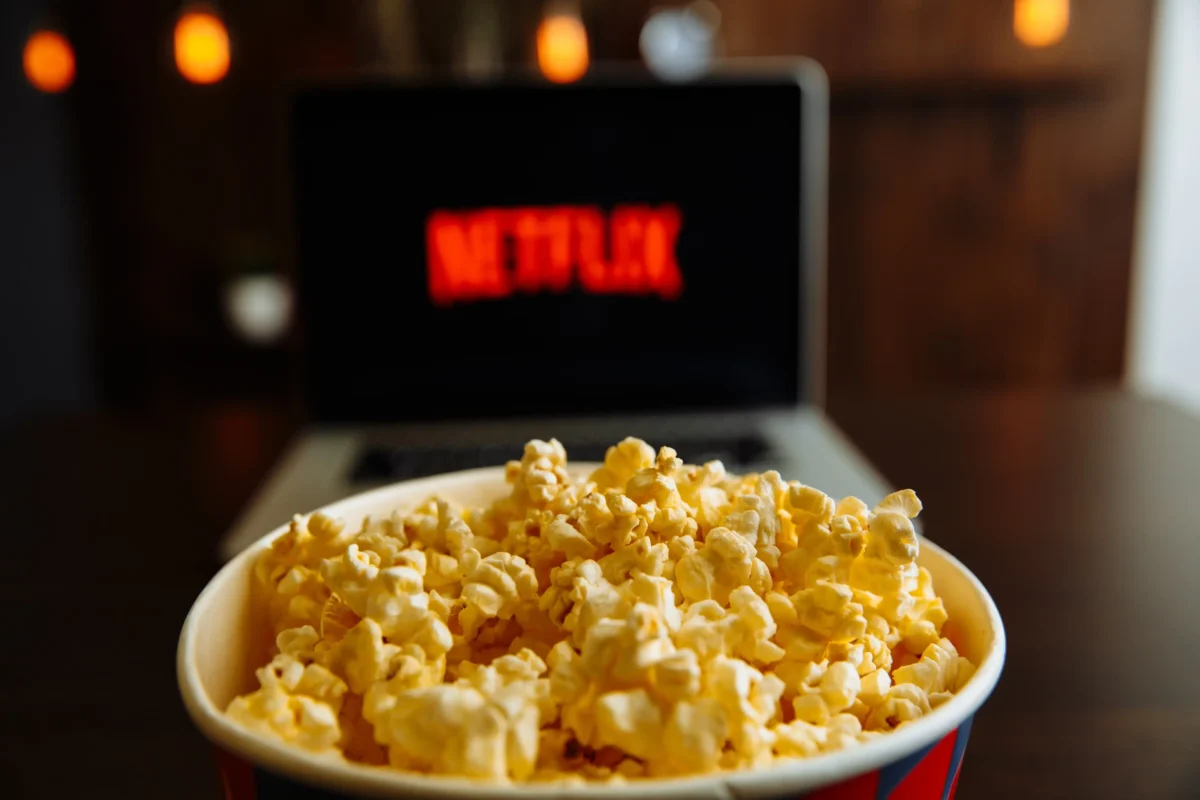 Před notebookem s Netflixem stojí popcorn. 