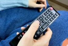 Člověk v ruce drží ovladač od TV.