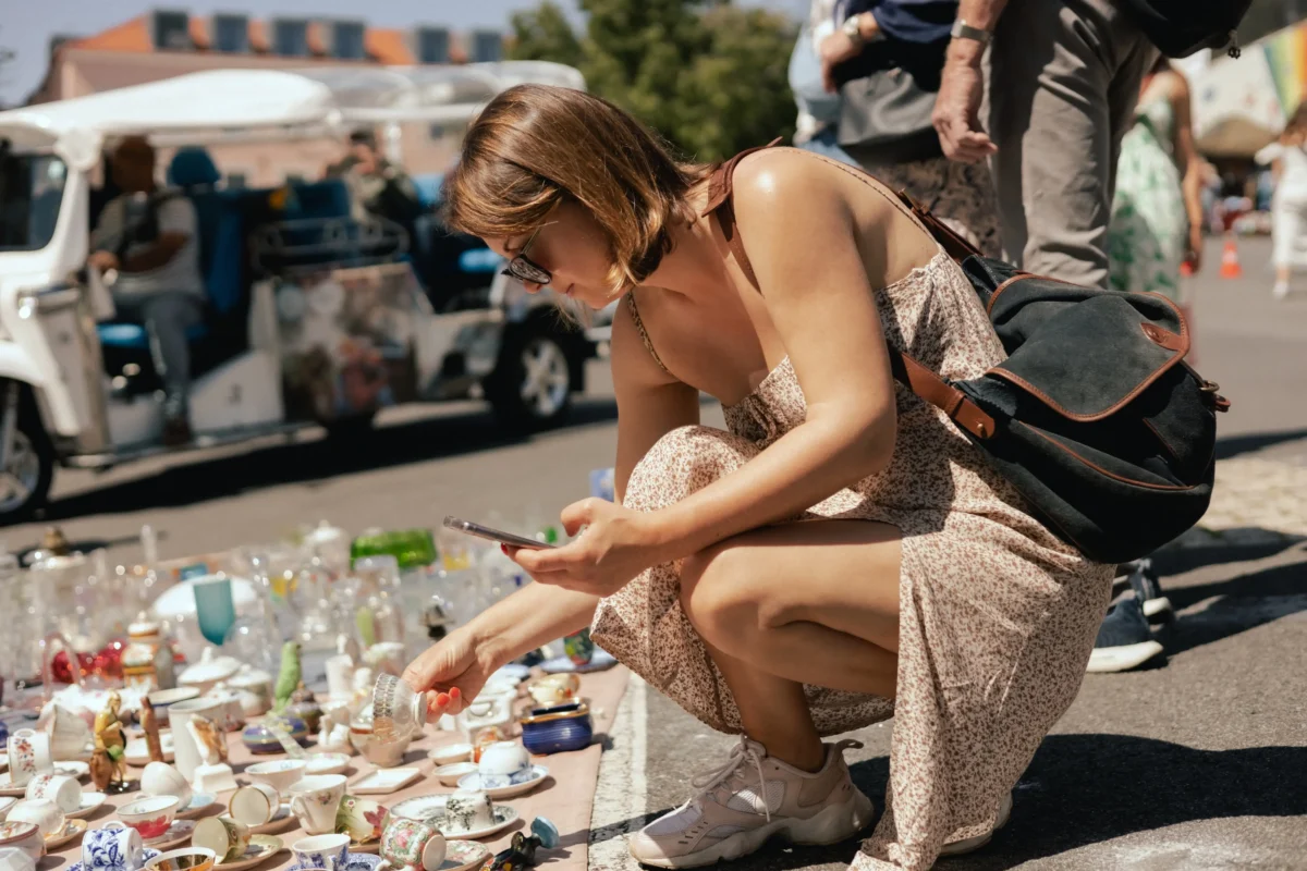 Žena se přehrabuje ve věcech na zemi. 