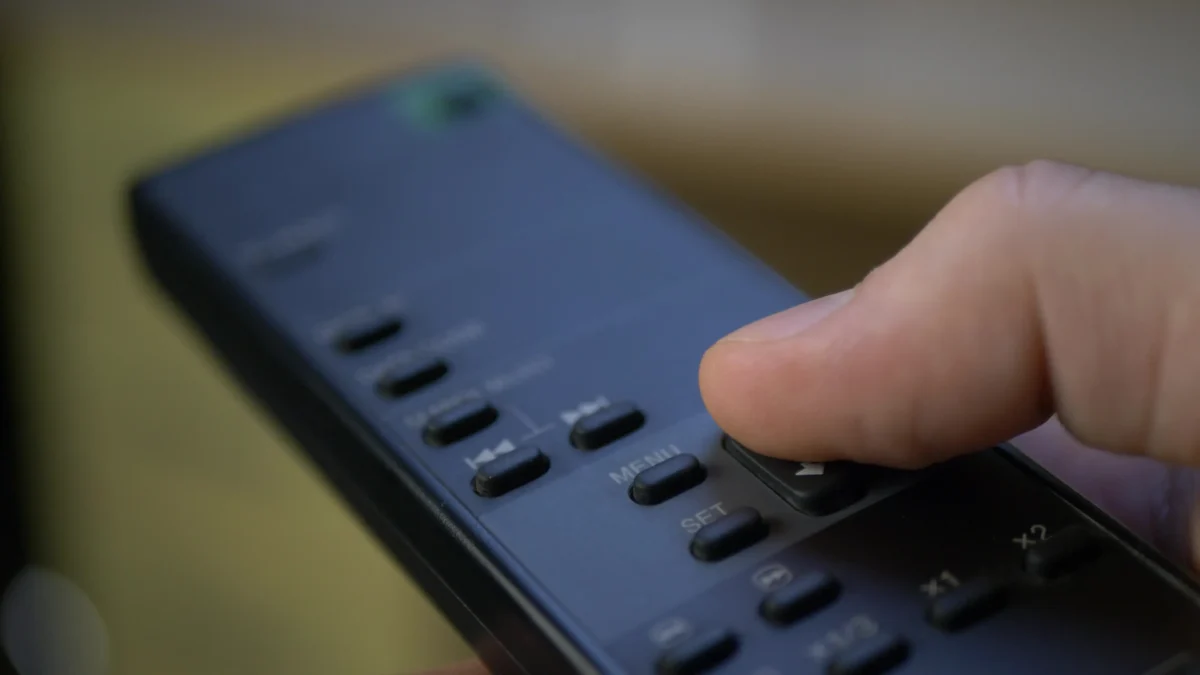 Člověk mačká tlačítko na ovladači. 