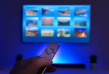 Člověk ovladačem míří na obrazovku TV.