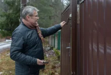 Muž zavírá branku.