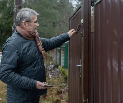 Muž zavírá branku.