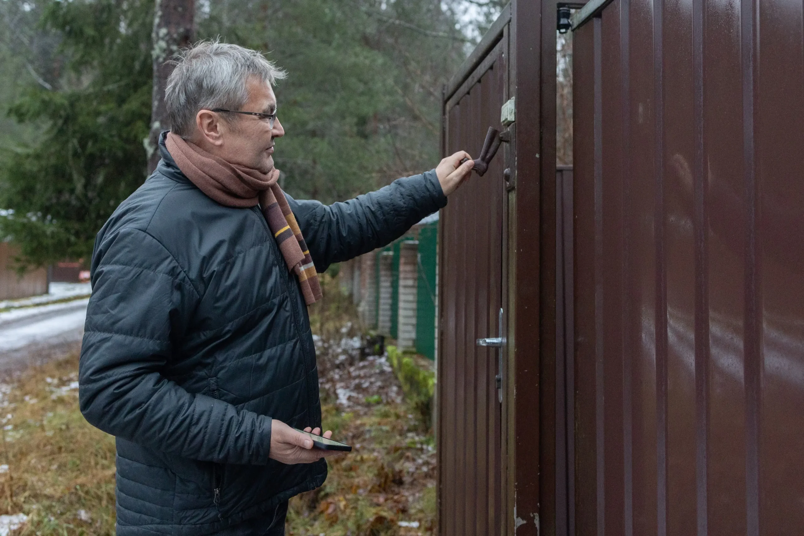 Muž zavírá branku.