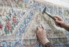 Člověk opravuje perský koberec.